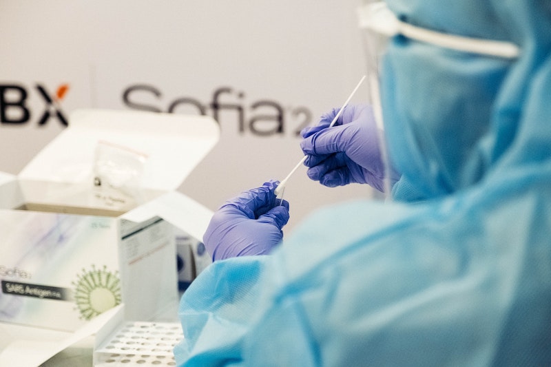 Eine Person in Schutzkleidung ist in einem Labor. Jetzt erfahren Sie, wie die Symptome einer Infektion mit Corona aussehen und wie weit Unternehmen bei der Entwicklung eines Impfstoffs sind.